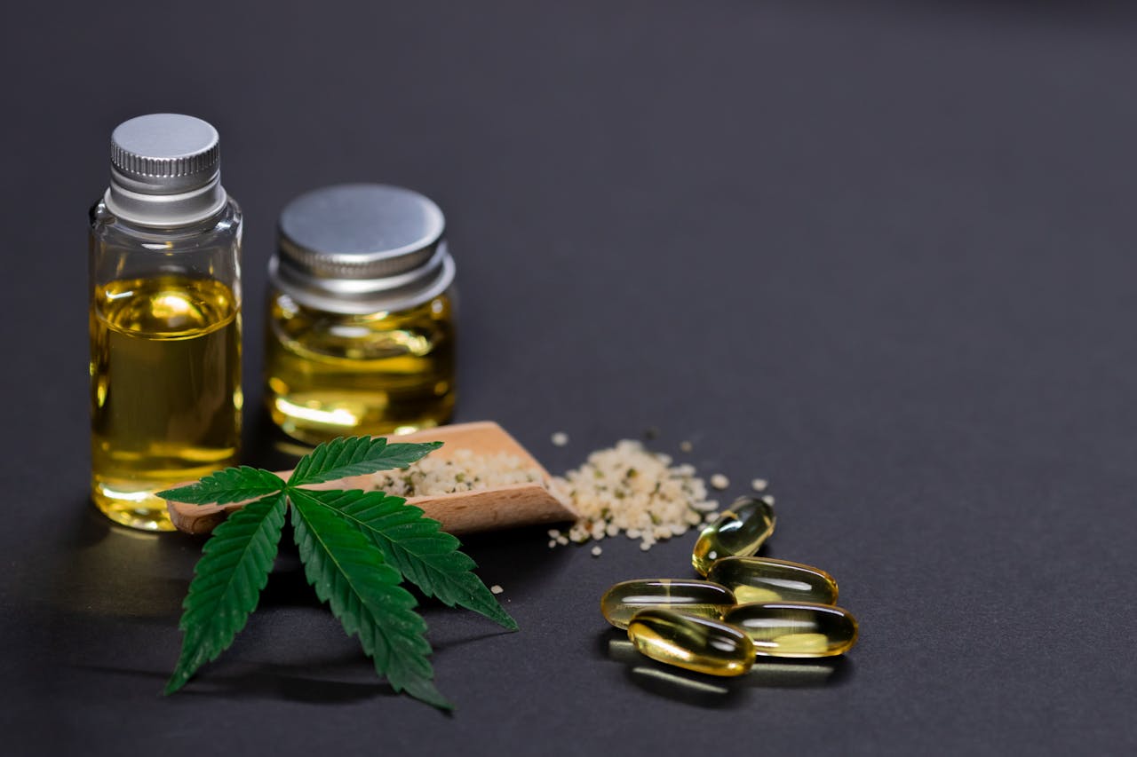 Services Assorted cannabis products including hemp seeds, oil, and capsules on dark background.